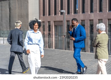 Business people walking and talking to the mobile outdoors each other in proper mood - Powered by Shutterstock