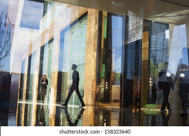 Business People Walking Through The Lobby Of An Office 