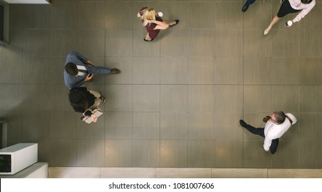 Business People Walking Through A Office Hallway. Defocused  People In A Lobby.