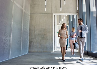 Business People Walking While Talking In Office Hall