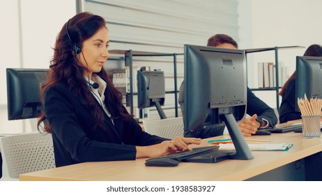 Business people wearing headset working in office to support remote customer or colleague. Call center, telemarketing, customer support agent provide service on telephone video conference call. - Powered by Shutterstock