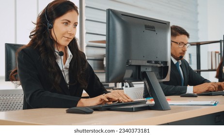 Business people wearing headset working in office to support remote customer or colleague. Call center, telemarketing, customer support agent provide service on telephone video conference call. Jivy - Powered by Shutterstock