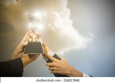 Business people winner holding trophy award after win competitor.