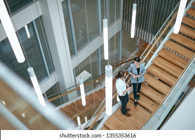 Business People Working In Modern Office. Man And Woman Walking On Stairs In Contemporary Business Center Interior. High Resolution