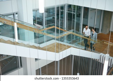 Business People Working In Modern Office. Man And Woman Walking On Stairs In Contemporary Business Center Interior. High Resolution