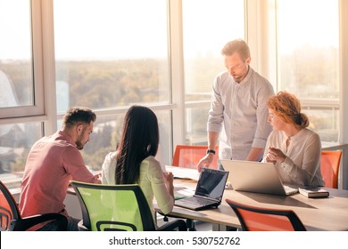 Business people working on laptop computer and listening to their boss in board room in office. Boss explaining one of his worker how to be successful. - Shutterstock ID 530752762