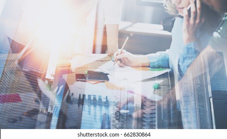 Business people working process concept.Young coworkers working together in modern office.Woman using mobile phone.Double exposure,skyscraper building blurred background.Horizontal - Shutterstock ID 662830864