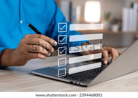 Business performance monitoring and evaluation concept, Take an assessment, Business man using laptop and tablet online checklist survey, Filling out digital checklist, Questionnaire with checkboxes.