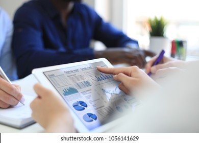 Geschäftsleute analysieren Finanzstatistiken auf dem Tablettenbildschirm.