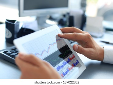 Geschäftsleute analysieren Finanzstatistiken auf dem Tablettenbildschirm 