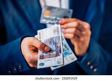 Business person holds russian roubles and plastic credit card - Shutterstock ID 250091929