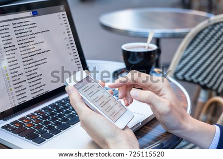Business person reading emails on smartphone and laptop computer screen online, communication and marketing concept