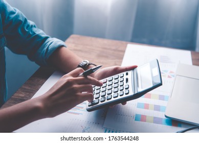  Business Person Sitting At A Desk At An Office By Using The Calculator To Work. Business Concept Analysis And Planning