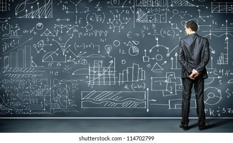 Business person standing against the blackboard with a lot of data written on it - Powered by Shutterstock