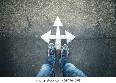 Business Person Standing At A Crossroads. Conceptual Business Decision Background. Point Of View Perspective Used.