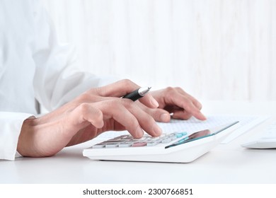 Business person using calculator in office