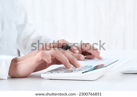 Business person using calculator in office