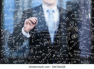 A Business Person Is Writing Down Math Formulas On The Glass Screen In The Evening Modern Panoramic Office.