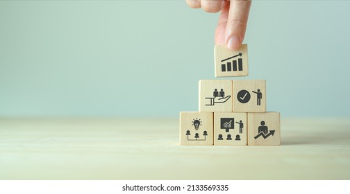 Business, personal development concept. Improving and developing  competency, performance. Hand holds wooden cubes with growth icon stading with brainstorm, training, mentor, support and improve icon - Shutterstock ID 2133569335