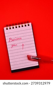 business plan write in notepad on red background