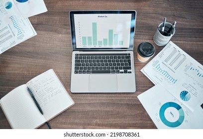 Business Planning, Finance And Marketing With Laptop On Office Table Or Desk. Social Media Mangement, Budget Graphs Or Ppt Presentation With Modern Technology, Notebook And Paperwork Above Background