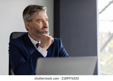 Business Planning. Portrait Of Thoughtful Mature Businessman At Workplace In Office, Pensive Middle Aged Manager In Suit Sitting At Desk With Laptop Computer And Looking Away, Closeup Shot