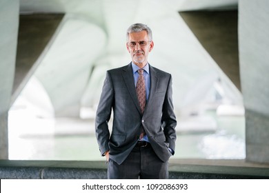 Business Portrait Head Shot Of A Confident, Professional And Experienced Caucasian White Business Man. He Is Mature And Is Wearing A Shirt And Tie In A City In Asia (Singapore).