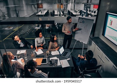 Business presentation. A group of handsome business people working in a spacious conference room in a large business center. Concept of startup, projects, planning, results, strategy.