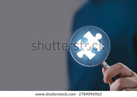 Business problem solving concept with magnifying glass highlighting puzzle piece, symbolizing solution finding, analysis, strategy planning, innovation process, decision making corporate environment