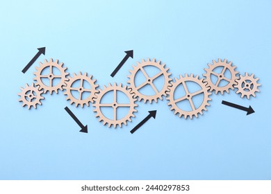 Business process organization and optimization. Scheme with wooden figures and arrows on light blue background, top view