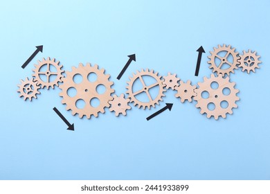 Business process organization and optimization. Scheme with wooden figures and arrows on light blue background, top view