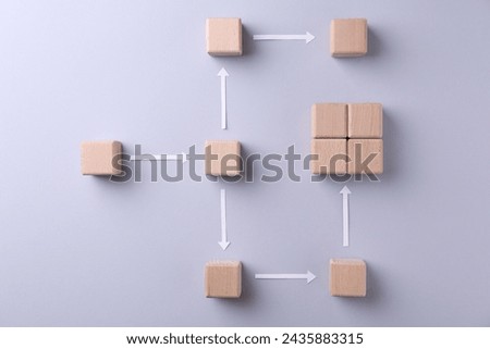 Business process organization and optimization. Scheme with wooden cubes and arrows on light grey background, top view