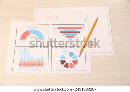 Business process planning and optimization. Documents with different types of graphs and pencil on wooden table