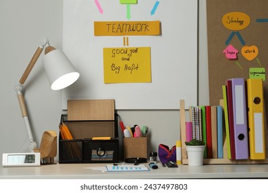 Business process planning and optimization. Workplace with lamp, colorful paper notes and other stationery on table