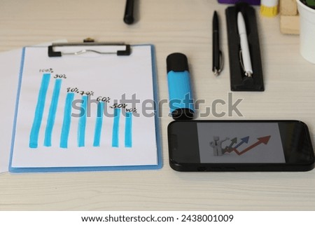 Business process planning and optimization. Workplace with graph, smartphone and different stationery on wooden table