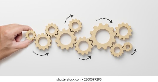 Business process and workflow automation with flowchart. Hand holding wooden cog flowing process management on white background
