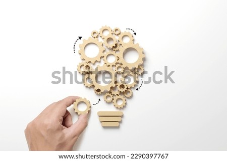 Business process and workflow automation with flowchart. Hand holding wooden cog flowing process management lightbulb shape on white background