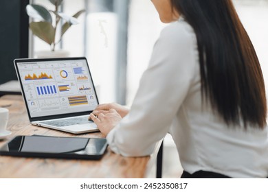 Business professional analyzing sales performance dashboard on laptop screen