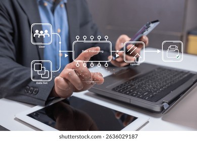 A business professional interacts with virtual data processing graphics on a touch screen, with a laptop, smartphone, and tablet on the desk.
