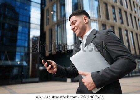 Business professional smiles while using smartphone outside modern office building during a productive workday