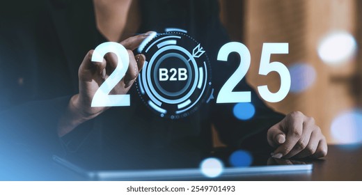 A business professional touches a digital interface displaying 2025 and B2B graphics. Futuristic design. Business strategy and forecast concept - Powered by Shutterstock