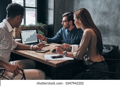 Business professionals. Group of young confident business people analyzing data using computer while spending time in the office - Powered by Shutterstock