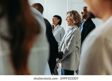 Business professionals laughing and enjoying a light moment during a conference event, fostering a positive and engaging atmosphere. - Powered by Shutterstock