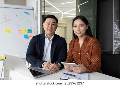 Business professionals working together in contemporary office environment with laptop and tablet. Image portrays teamwork, discussion, and modern business practices. - Powered by Shutterstock