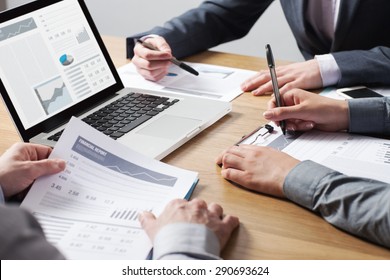 Business professionals working together at office desk, hands close up pointing out financial data on a report, teamwork concept - Shutterstock ID 290693624