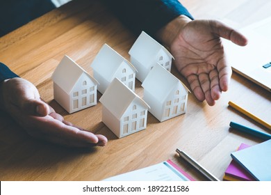 Business property,real estate and investment concepts with investor and white model house on desk background. - Shutterstock ID 1892211586
