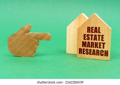 Business Real Estate Concept. On A Green Surface, A Hand Points To A House With An Inscription - Real Estate Market Research