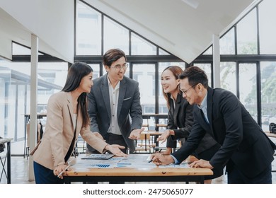 business related meeting Asian Business Team Discusses Strategy for Starting a Financial Process Analysis Project Successful Asian businessman working on a plan - Powered by Shutterstock