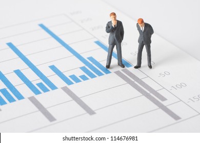 Business Report, Graph And Business Figurines Illustrating Profit Decrease Analyze.