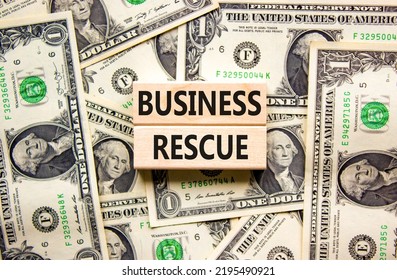 Business Rescue Symbol. Concept Words Business Rescue On Wooden Blocks On A Beautiful Background From Dollar Bills. Business Rescue And Support Concept. Copy Space.